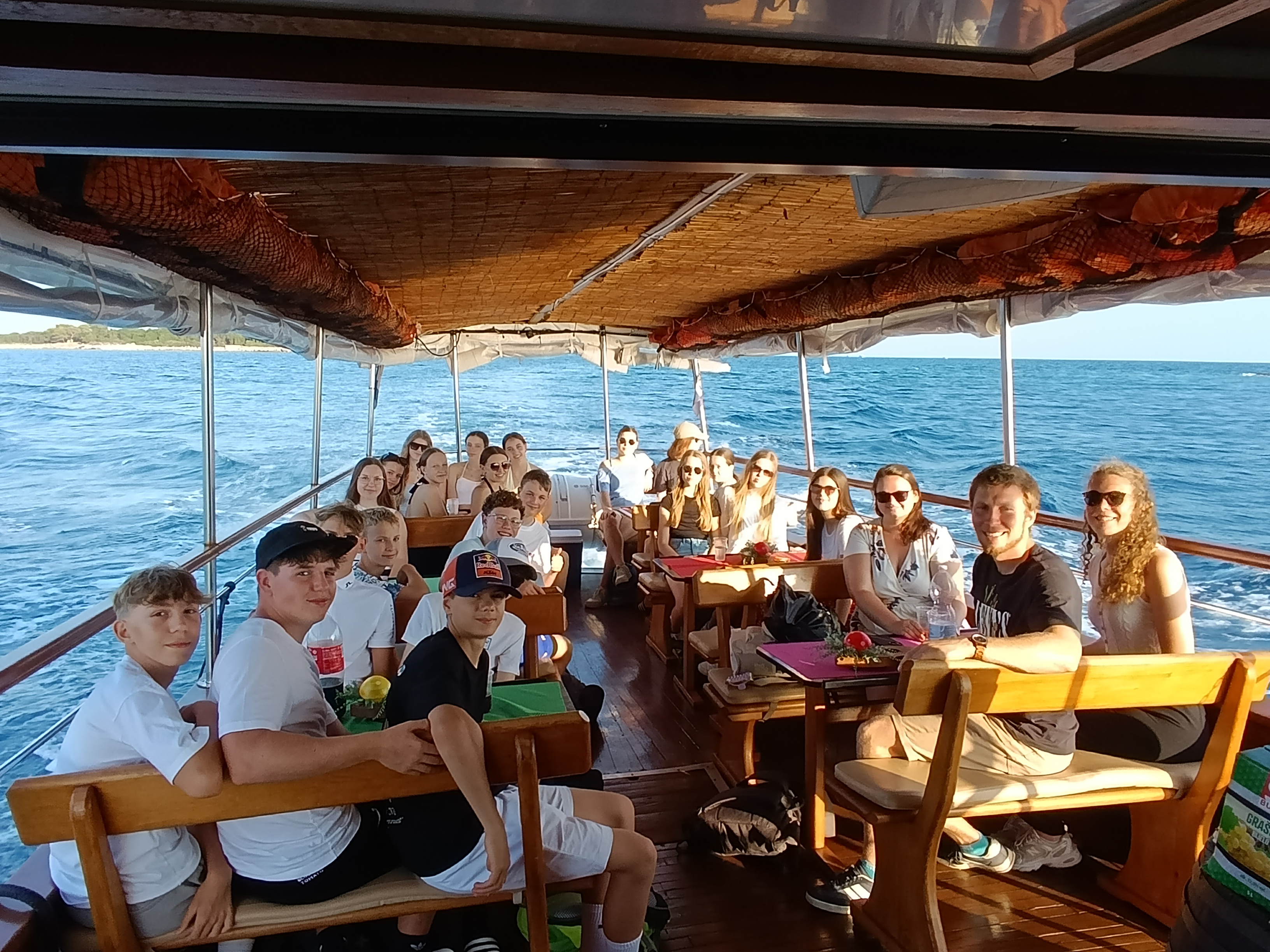 Die Schülerinnen machen einen Bootsausflug, sitzend an Deck fotografiert